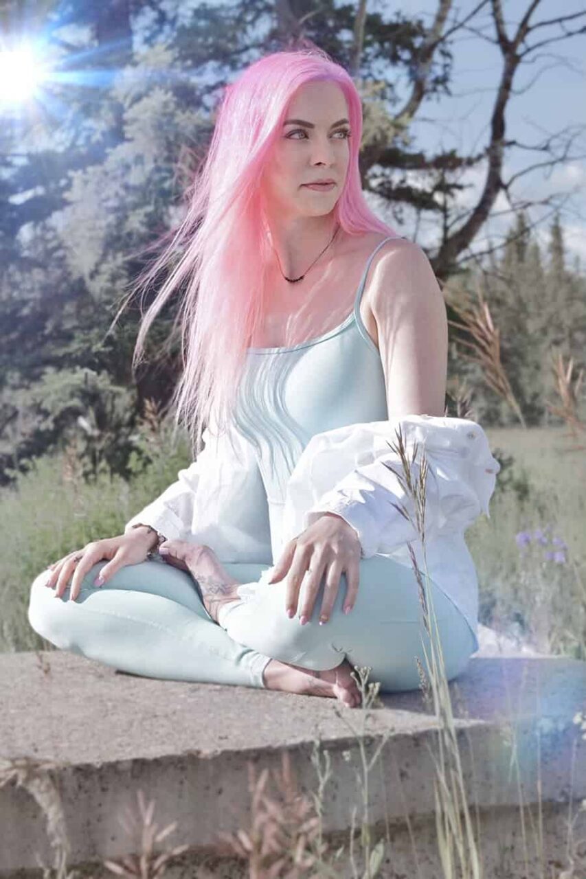 Rachel Cadrin, Certified Canadian Counsellor and Art Therapist, sitting in a yoga pose in nature.